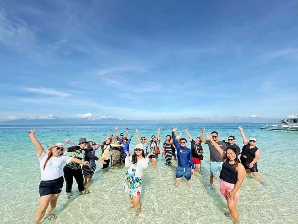 Large group of guests celebrating together in crystal clear shallow water